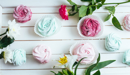 Rose marshmallows and beautiful flowers on a white background wo
