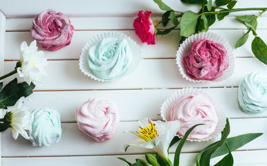 Rose marshmallows and beautiful flowers on a white background wo