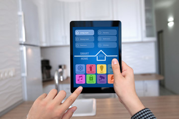 male hands holding tablet with app smart home kitchen house