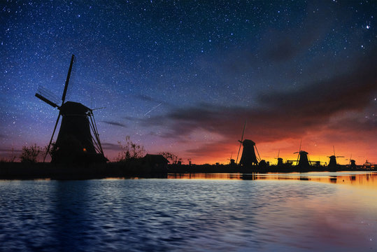 Starry sky over Dutch windmills from the canal in Rotterdam