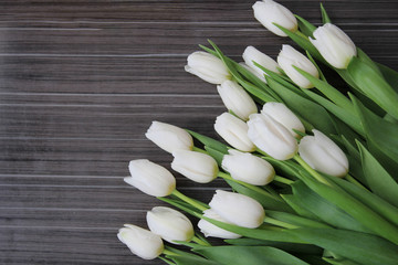 A large bouquet of white tulips with green leaves