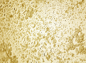 Snow and drops on orange toned car glass with blur effect.