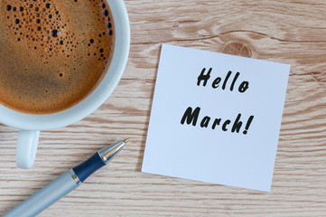 Hello MARCH - note at wooden office table with pen and mug of morning coffee. Spring concept - Powered by Adobe