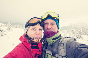 Couple of travelers taking selfie in the winter mountain
