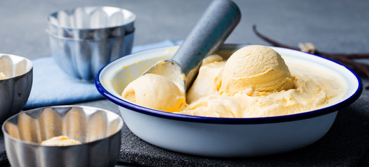 Homemade vanilla, caramel ice cream in vintage bowl. Organic product on a grey stone background.