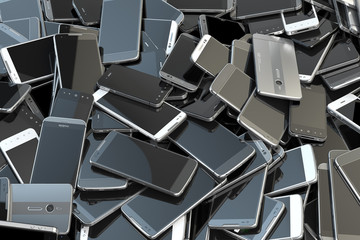 Heap of different smartphones. Mobile phone technology concept background.