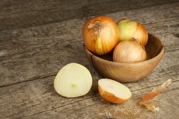 Fresh onion on an old wooden table. Food preparation. Slicing onions.