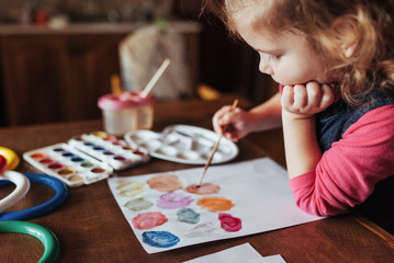 Cute happy little girl, adorable preschooler, painting with wate