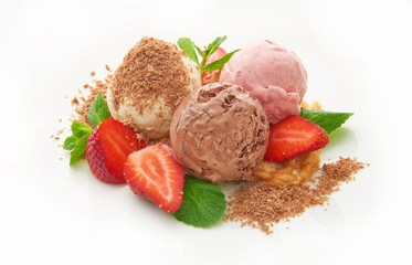 Three scoops of chocolate, strawberry and vanilla ice cream with mint and chocolate chips on the white background