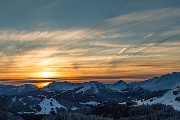 Fototapeta na wymiar Vibrant sunset over a white snowy mountain range