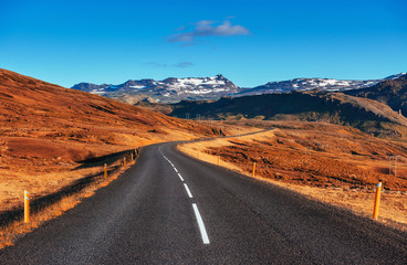 Road in mountains. Fantastic autumn landscape. Bridge over a cha