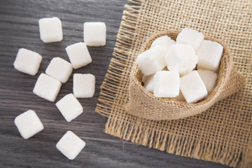 Sugar cubes on the wooden background