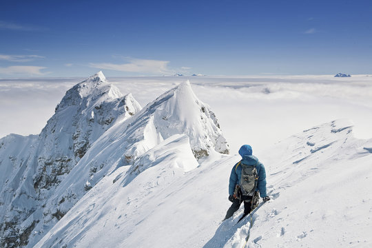 Rear view of man standing on snowcapped mountain
