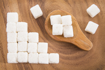 Sugar cubes in wooden spoon