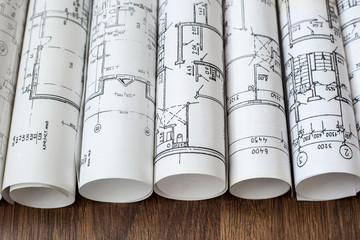 Architect workplace. Architectural project, blueprints, blueprint rolls on wooden desk table....