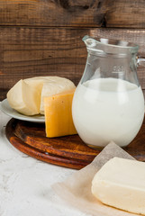 Selection of organic farming household dairy products - milk, cream (yogurt), cheese, cottage cheese, white stone concrete table. 