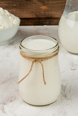 Selection of organic farming household dairy products - milk, cream (yogurt), cheese, cottage cheese, white stone concrete table. 
