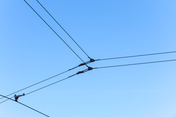 Fototapeta premium Overhead electric tram lines against a blue sky
