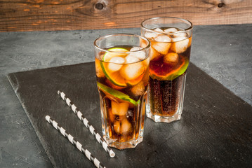Cocktail Cuba Libre (rum, cola, lime and ice) in glasses copy space
