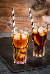 Cocktail Cuba Libre (rum, cola, lime and ice) in glasses copy space