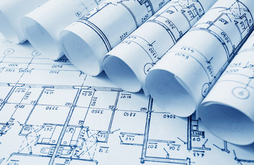 Architect workplace. Architectural project, blueprints, blueprint rolls on wooden desk table....