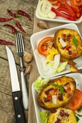 Stuffed baked potatoes on a wooden table. Healthy food. Homework dinner.