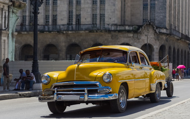 Amerikanischer gelber Oldtimer fährt auf der Hauptstraße durch Havanna Kuba - Serie Kuba Reportage