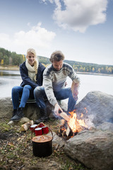Hiking Couple Preparing Bonfire On Lakeshore