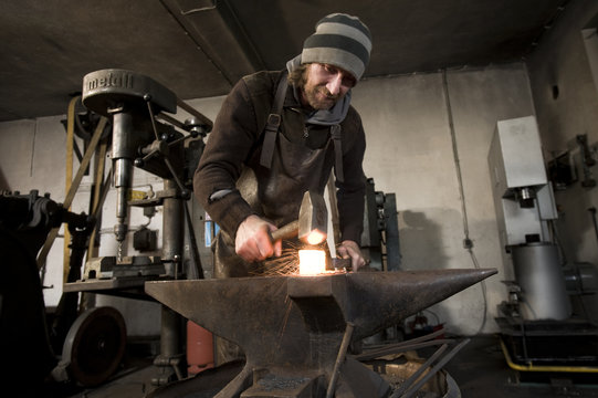 Blacksmith hammering metal on an anvil, Landshut, Bavaria, Germany