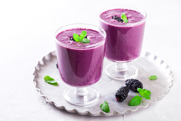 BlackBerry smoothie with Fresh Berries in glasses.Food or Healthy diet concept.Vegetarian.Copy space for Text. selective focus.