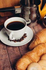 cup with a drink and croissants on a table, top view