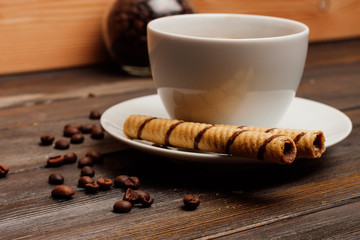 A cup and a chocolate tube on a saucer
