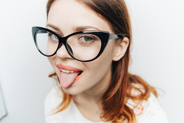 woman in glasses shows tongue