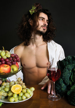 photo half naked curly guy at the table with fruit