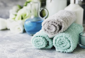 Obraz na płótnie Canvas Spa set on a white marble table with a stack of towels, selective focus