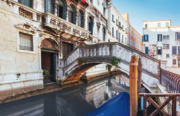 Fototapeta premium Traditional Gondolas on narrow canal between colorful historic houses in Venice Italy
