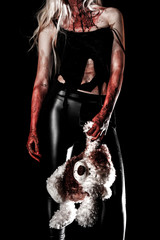 Bloody young woman holding a teddy bear
