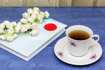 Herbal tea with book on blue table