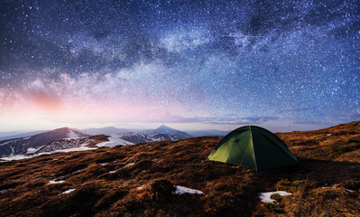 the starry sky above the tent in the mountains. Magic event in f