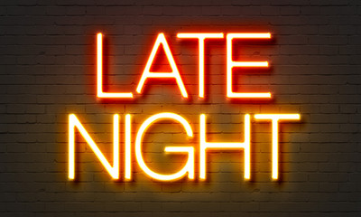 Late night neon sign on brick wall background.