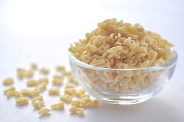 Alphabet pasta for children's meals. ABC pasta. Dry pasta in a glass bowl isolated on white
