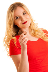 Cute young woman eating chocolate isolated over white background