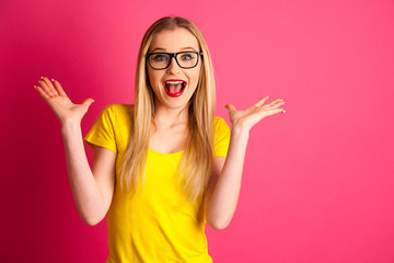 excited young woman over pink background gesture success with arms up in the air