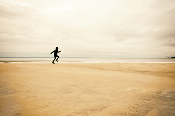Fototapeta na wymiar Person running on beach