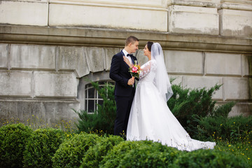 Happy newlyweds embracing in park after wedding ceremony