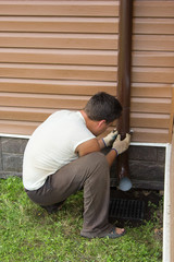 man sets drainpipe on the wall