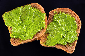 bread with fresh basil pesto on black
