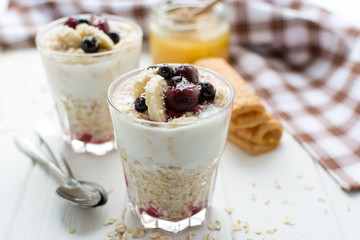 Healthy breakfast. Oatmeal with bananas, berries and honey