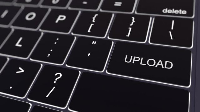 Dolly shot of black computer keyboard and glowing upload key. Conceptual 4K clip