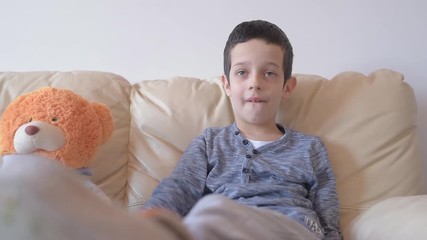 Young boy 6 years old watching TV on couch shot